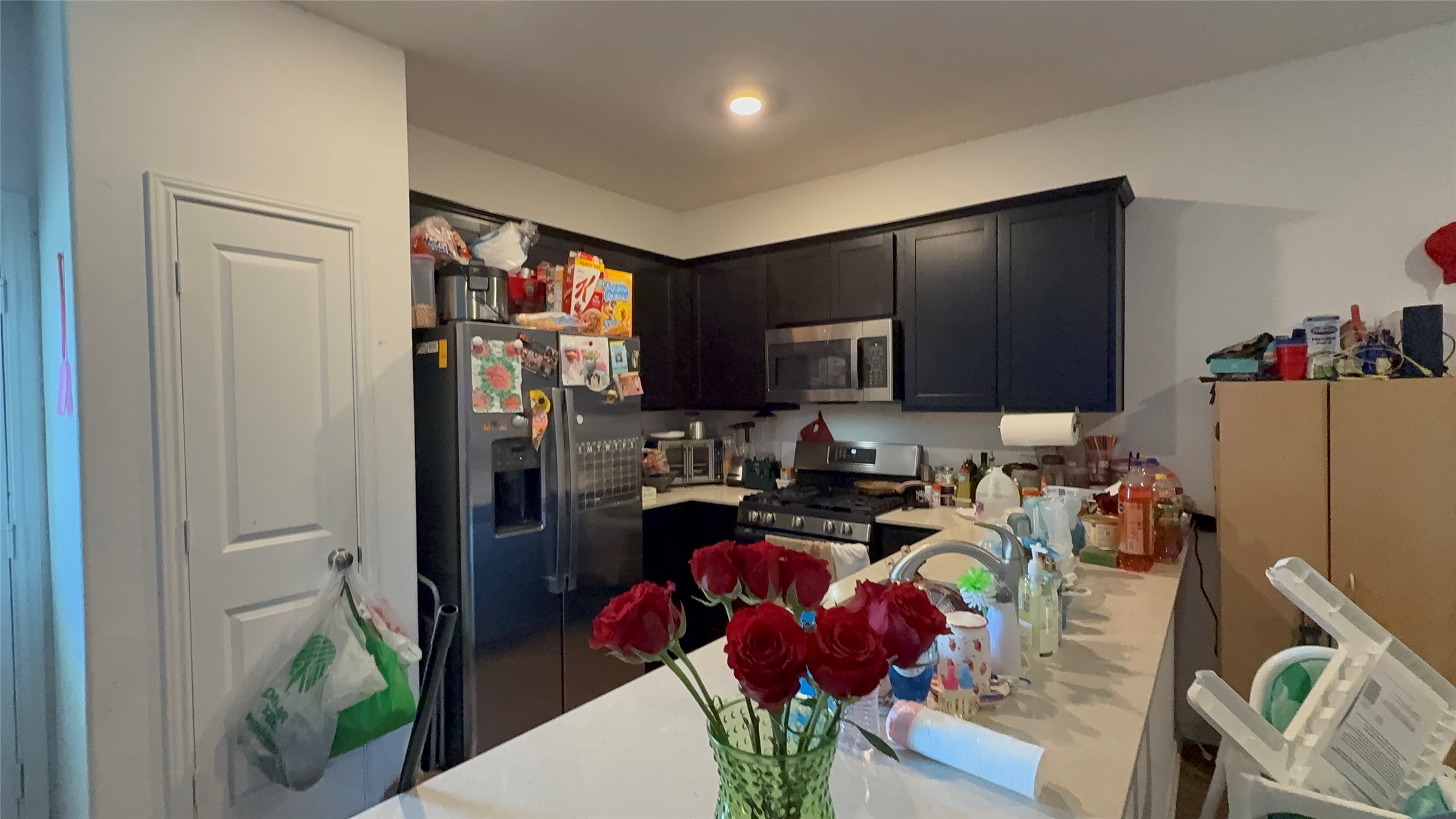 316 Geode Glen Maxwell, TX 78656 - Photo 5 of 24 a kitchen with stainless steel appliances granite countertop a refrigerator a stove a sink dishwasher and a dining table with wooden floor