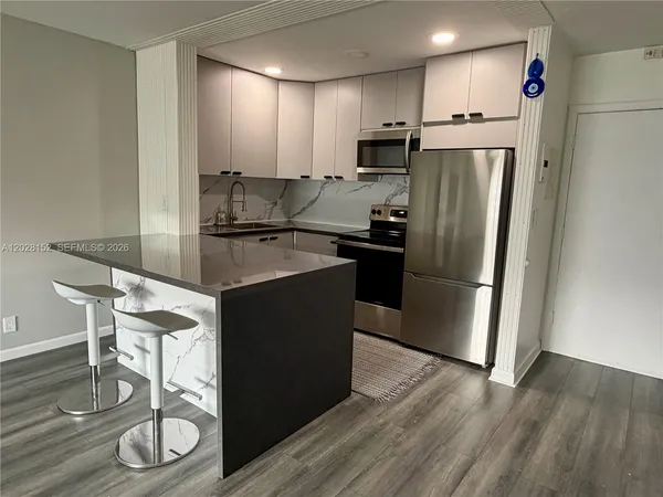a kitchen with kitchen island a counter top space cabinets and stainless steel appliances