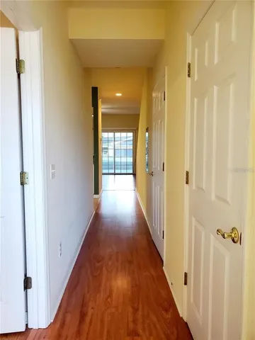 a view of a hallway with wooden floor and staircase