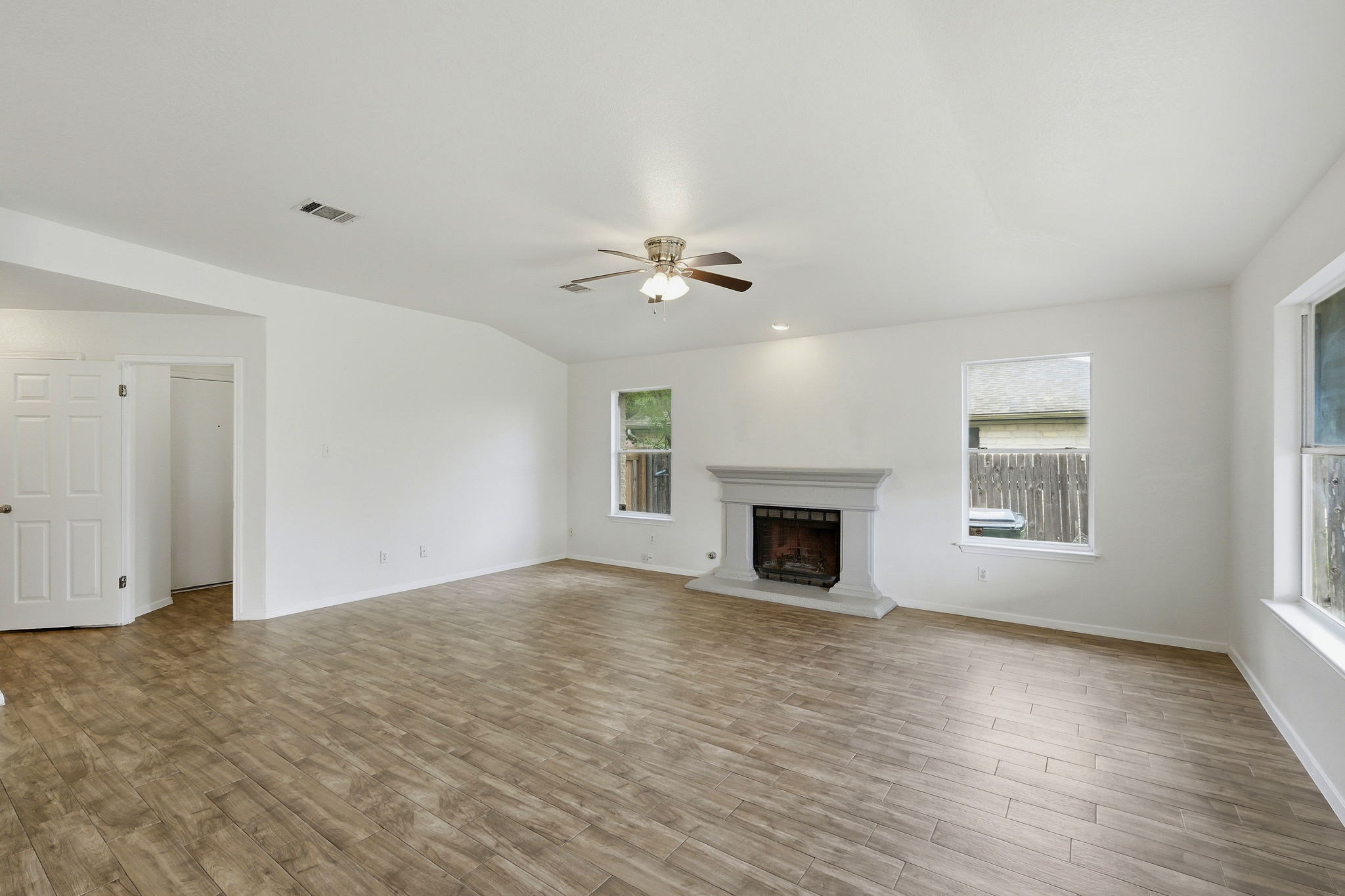 1005 Rolling Ridge Drive Round Rock, TX 78665 - Photo 2 of 18 A spacious living area features wide plank flooring and a classic fireplace, perfect for gatherings.