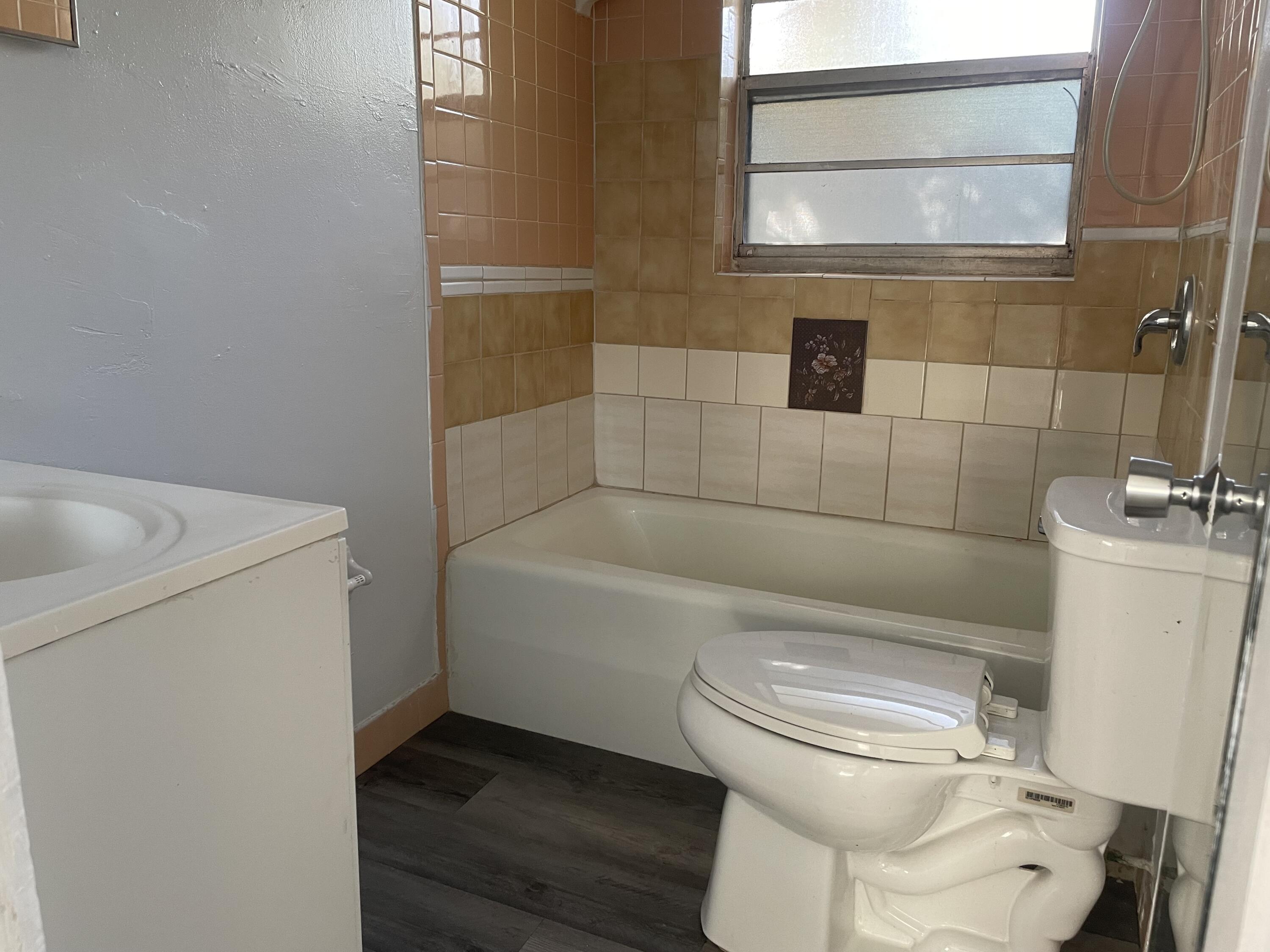 105 Southwest 5th Avenue, Unit D Boynton Beach, FL 33435 - Photo 4 of 8 a white toilet sitting next to a bathroom sink