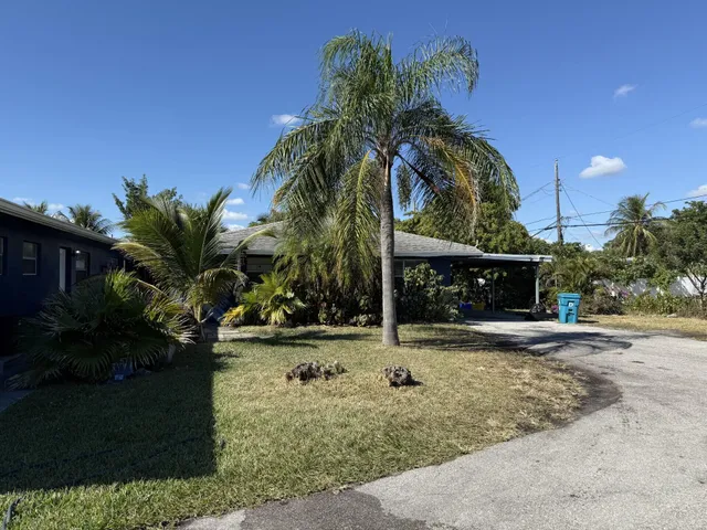 a view of a house with a yard and potted plants