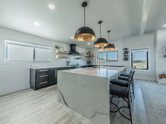 a kitchen with stainless steel appliances granite countertop a stove a sink and a wooden floors