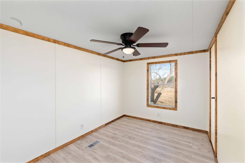 3393 Doe Trail Road Brownwood, TX 76801 - Photo 14 of 29 an empty room with wooden floor and windows