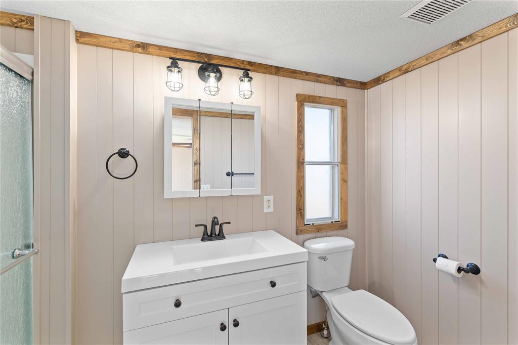 3393 Doe Trail Road Brownwood, TX 76801 - Photo 15 of 29 a bathroom with a sink a toilet and mirror