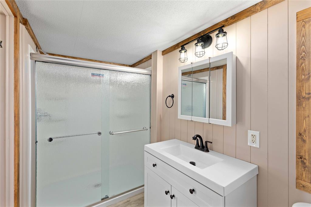 3393 Doe Trail Road Brownwood, TX 76801 - Photo 16 of 29 a bathroom with a bathtub a sink and a mirror