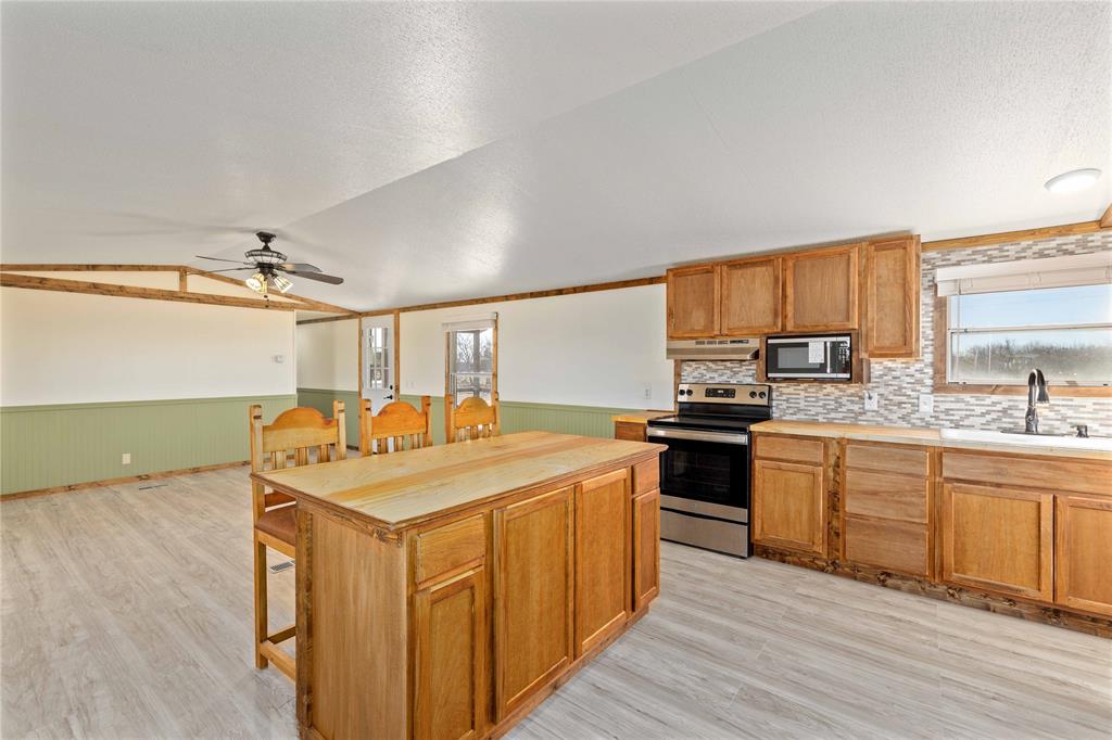 3393 Doe Trail Road Brownwood, TX 76801 - Photo 9 of 29 a kitchen with a stove top oven sink and cabinets