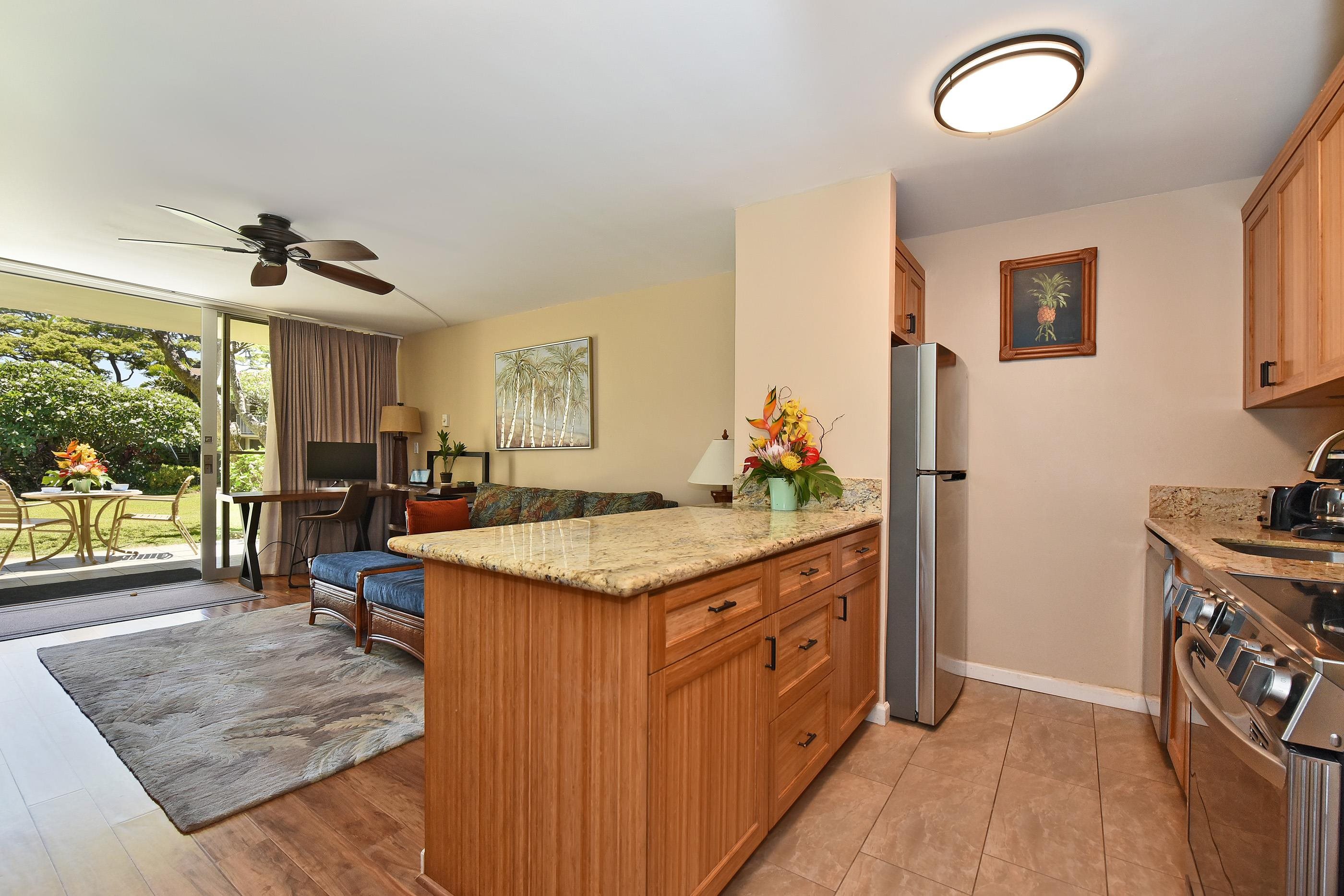 5315 Lower Honoapiilani Road, Unit F147 Lahaina, HI 96761 - Photo 12 of 41 a kitchen with granite countertop a stove a sink and a refrigerator