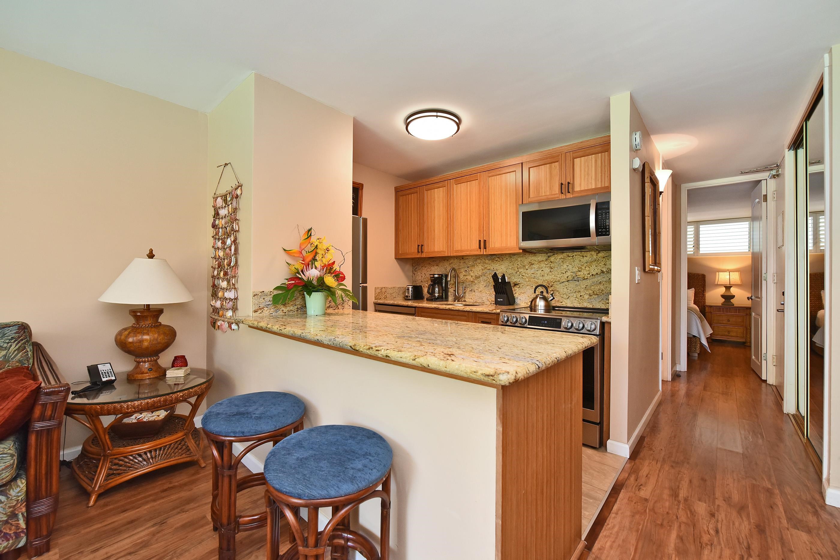 5315 Lower Honoapiilani Road, Unit F147 Lahaina, HI 96761 - Photo 13 of 41 a kitchen with a stove a sink and a refrigerator