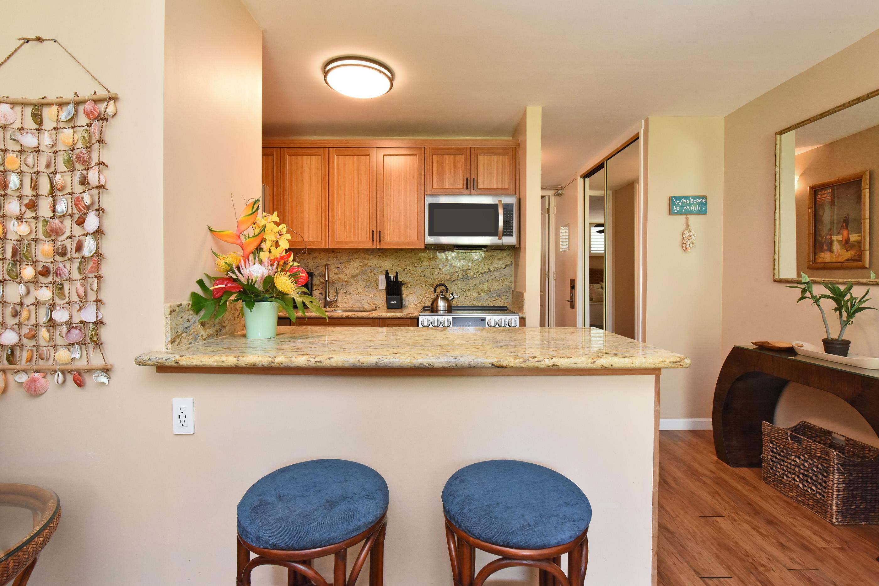 5315 Lower Honoapiilani Road, Unit F147 Lahaina, HI 96761 - Photo 14 of 41 a kitchen with granite countertop a sink and a stove