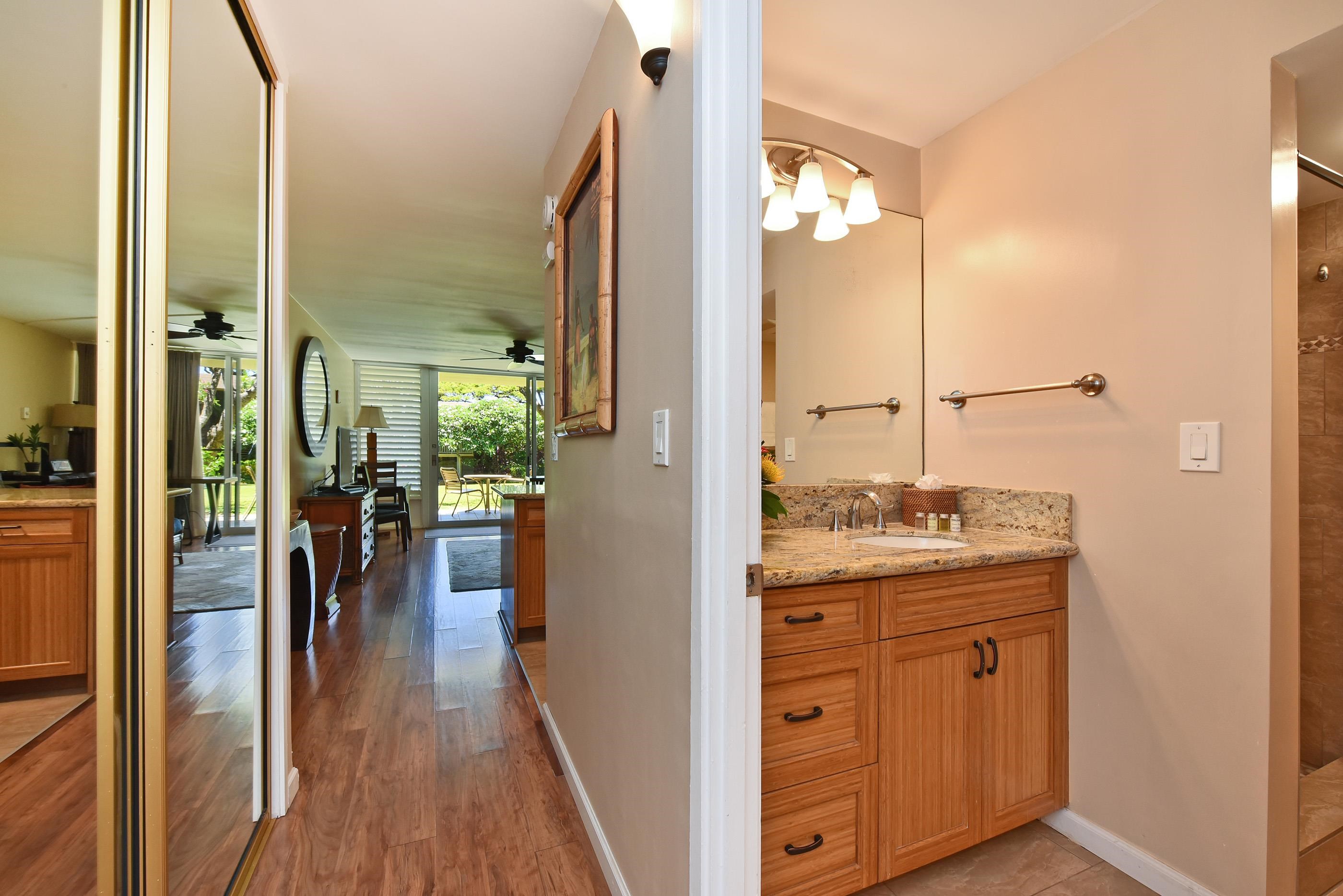 5315 Lower Honoapiilani Road, Unit F147 Lahaina, HI 96761 - Photo 18 of 41 a en suite bathroom with a granite countertop sink a mirror and shower