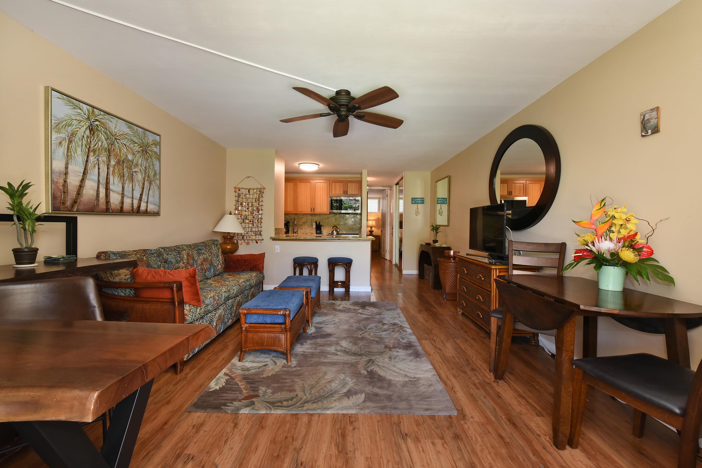 5315 Lower Honoapiilani Road, Unit F147 Lahaina, HI 96761 - Photo 5 of 41 a living room with furniture a fireplace and a large window