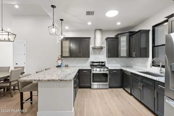 a kitchen with stainless steel appliances granite countertop a sink stove and refrigerator