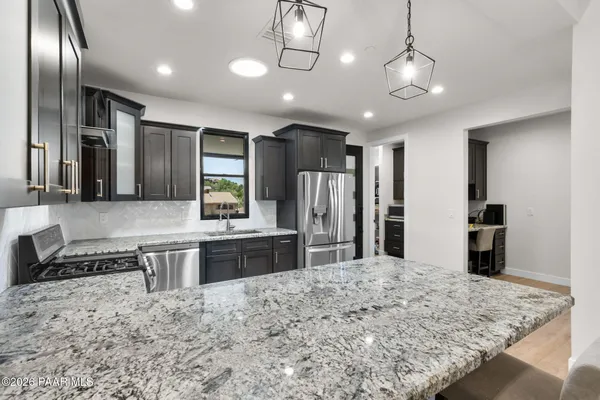 a large kitchen with kitchen island a large center island and stainless steel appliances