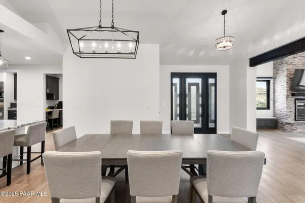 a living room with couches a dining table and chairs with wooden floor