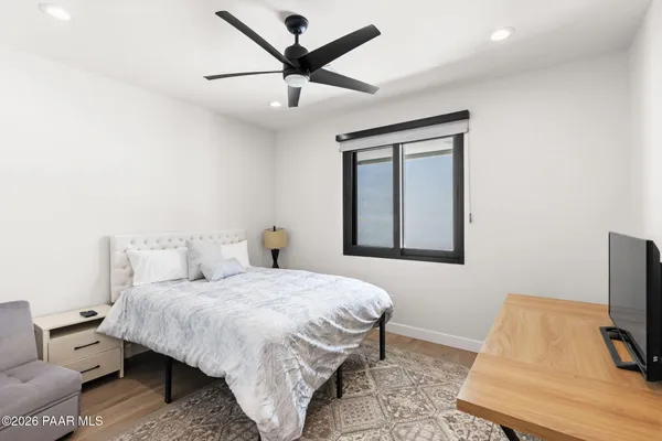 a bedroom with a bed a couch and a flat tv screen