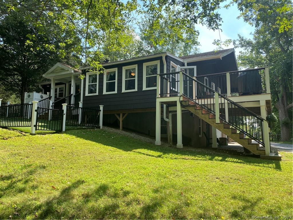 a view of a house with a yard and sitting area