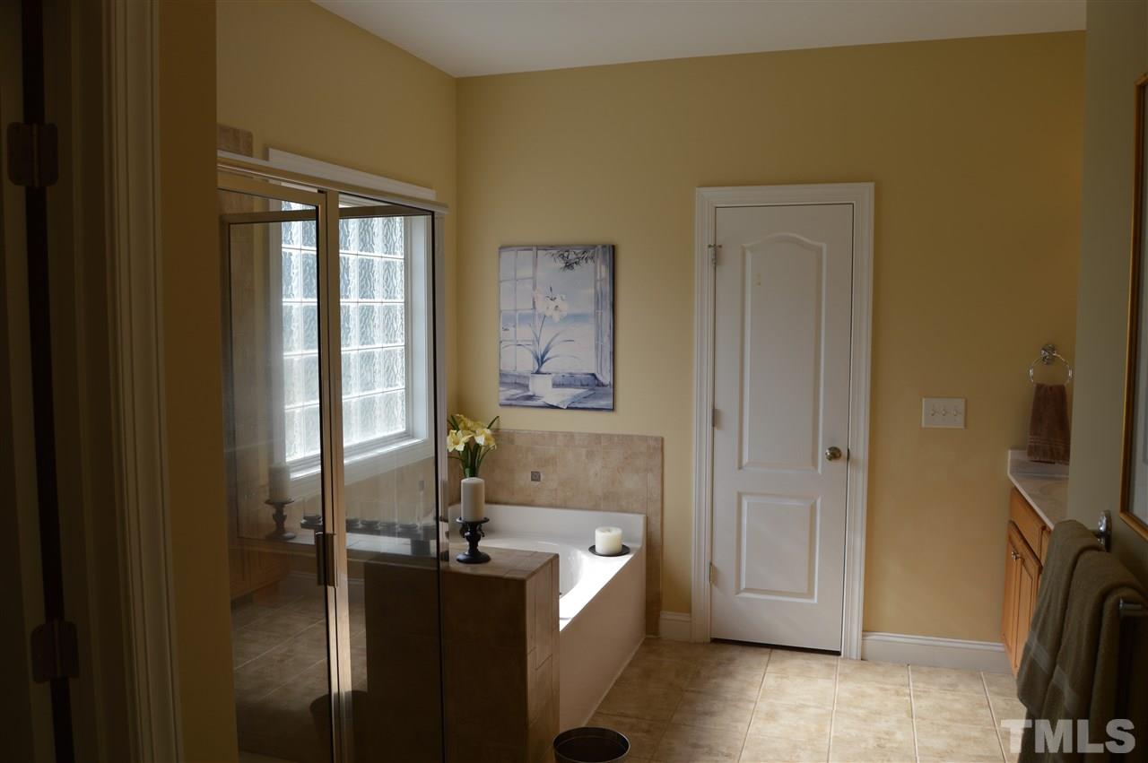 1069 Wheeler Pond Road Creedmoor, NC 27522 - Photo 12 of 22 a bathroom with a granite countertop sink a mirror and a bathtub