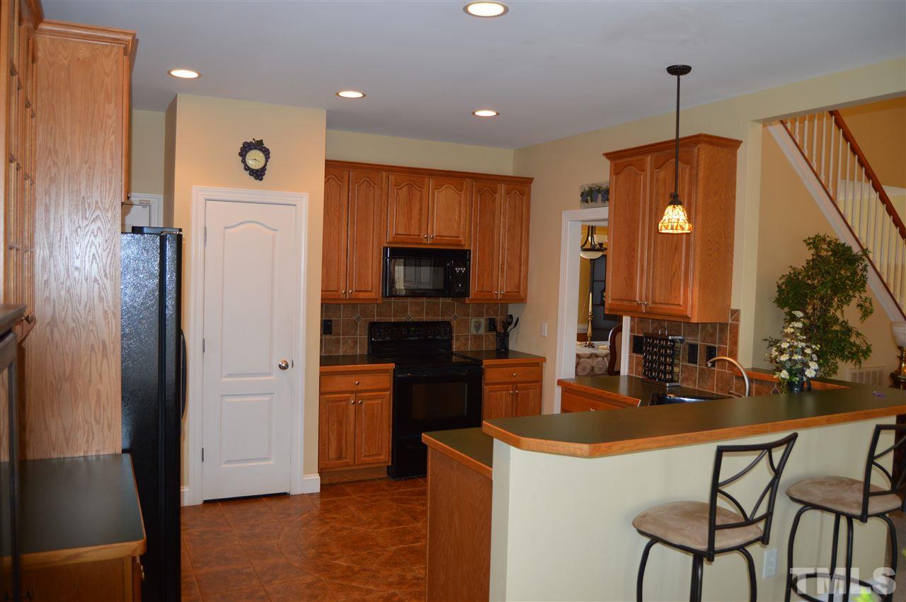 1069 Wheeler Pond Road Creedmoor, NC 27522 - Photo 9 of 22 a kitchen with stainless steel appliances granite countertop a refrigerator a stove top oven a sink and dishwasher