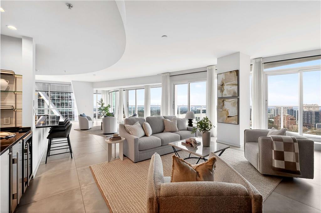 a living room with furniture wooden floor and floor to ceiling window