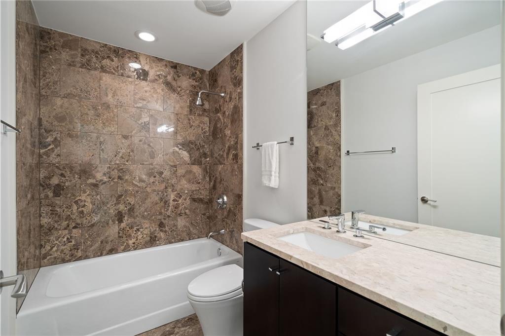 3325 Piedmont Road Northeast, Unit 2804 Atlanta, GA 30305 - Photo 48 of 65 a bathroom with a bathtub shower sink mirror vanity and toilet