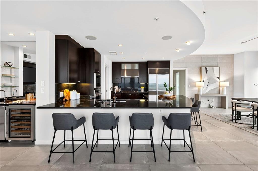 3325 Piedmont Road Northeast, Unit 2804 Atlanta, GA 30305 - Photo 9 of 65 a dining area with stainless steel appliances kitchen island granite countertop a dining table chairs and a refrigerator