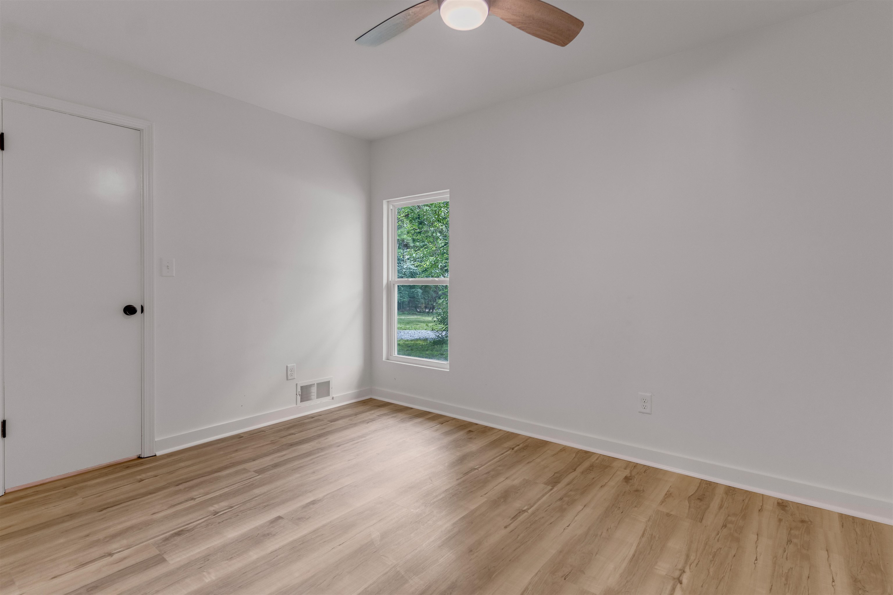 815 Fisherville Road Collierville, TN 38017 - Photo 18 of 40 a view of an empty room with wooden floor and a window