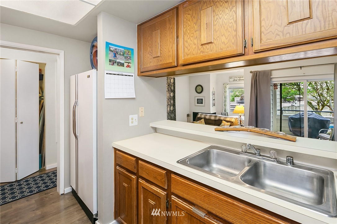 7407 Old Redmond Road, Unit 207 Redmond, WA 98052 - Photo 17 of 23 a kitchen with stainless steel appliances granite countertop a sink and a refrigerator with wooden cabinets