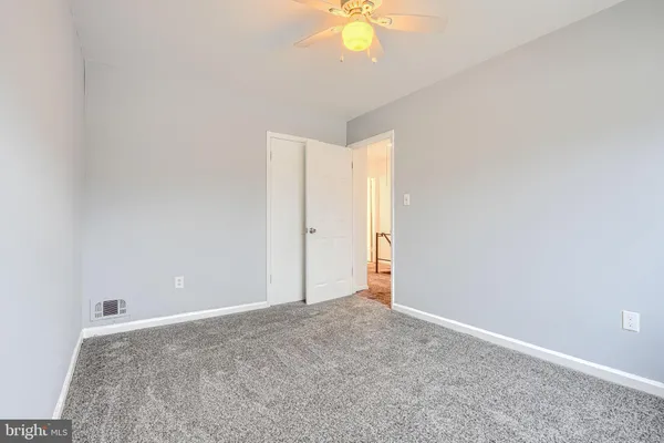 an empty room with a chandelier fan