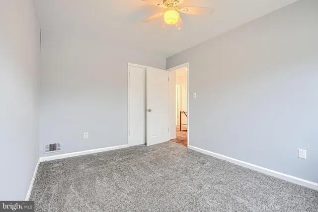 an empty room with a chandelier fan