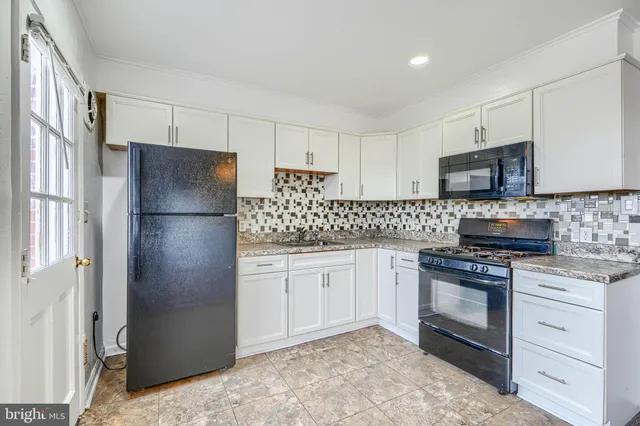 a kitchen with stainless steel appliances granite countertop a refrigerator stove and sink