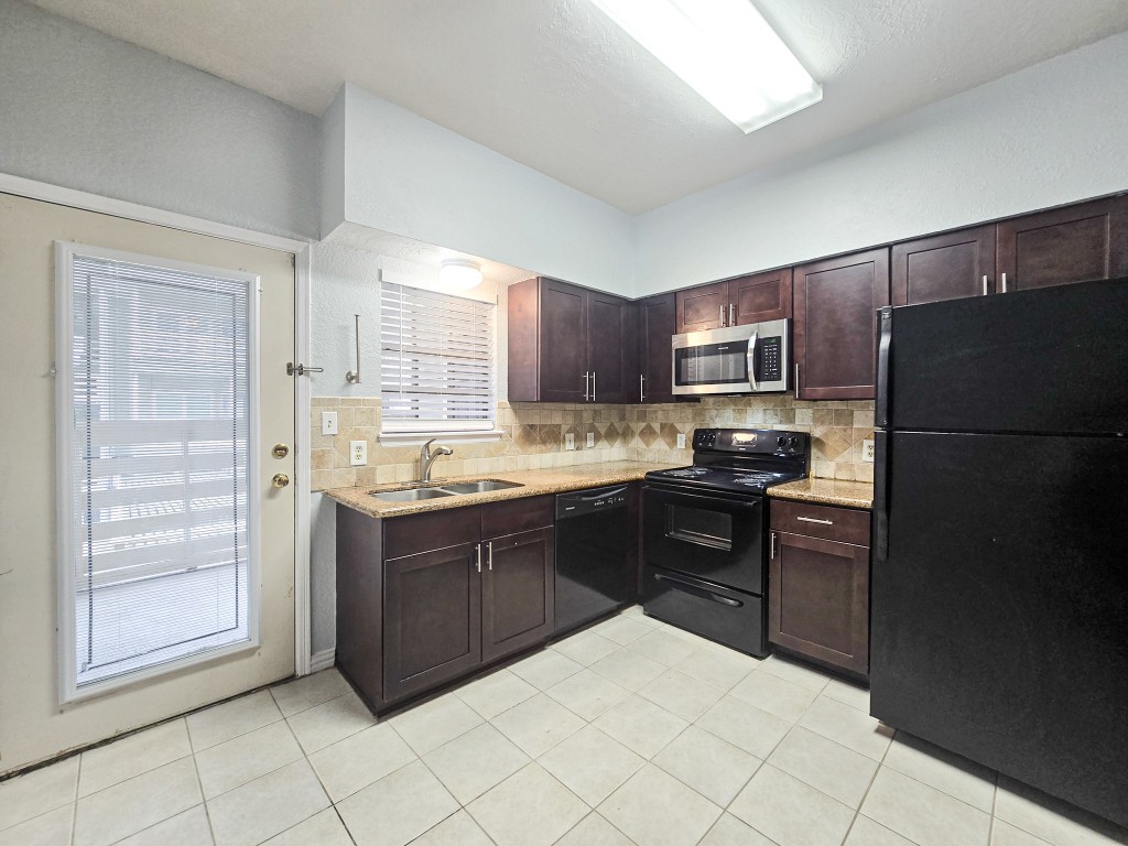 a kitchen with stainless steel appliances granite countertop a refrigerator and a stove top oven