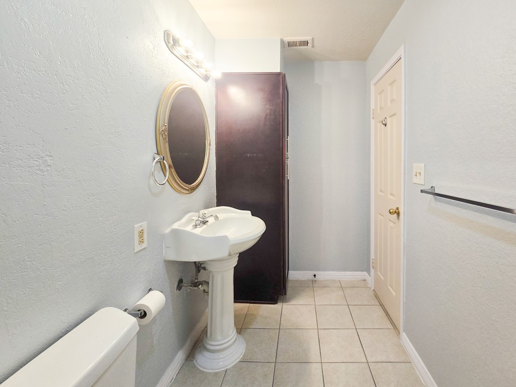 500 Ferry Road, Unit 323C Galveston, TX 77550 - Photo 13 of 17 a bathroom with a sink mirror and toilet