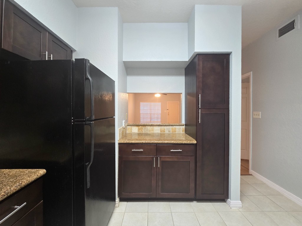 500 Ferry Road, Unit 323C Galveston, TX 77550 - Photo 2 of 17 a kitchen with a refrigerator and a sink