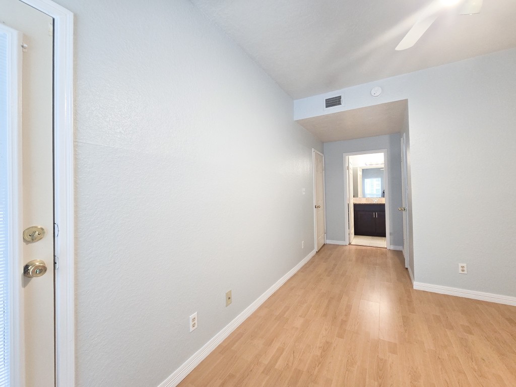 500 Ferry Road, Unit 323C Galveston, TX 77550 - Photo 8 of 17 a view of a hallway with wooden floor and a bathroom