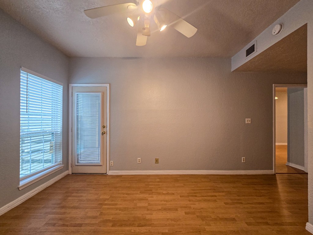 500 Ferry Road, Unit 323C Galveston, TX 77550 - Photo 9 of 17 a view of an empty room with window and wooden floor