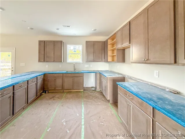 a large kitchen with stainless steel appliances granite countertop a sink and cabinets