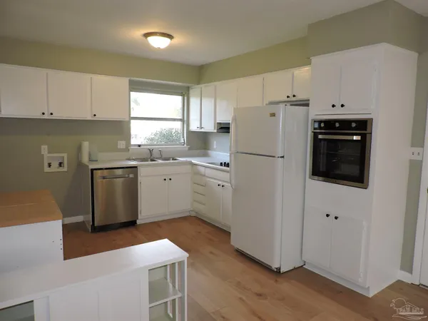 a kitchen with a refrigerator sink and cabinets