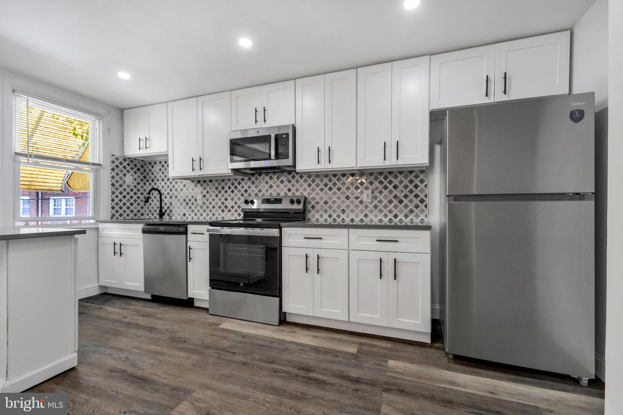 a kitchen with white cabinets white stainless steel appliances and sink