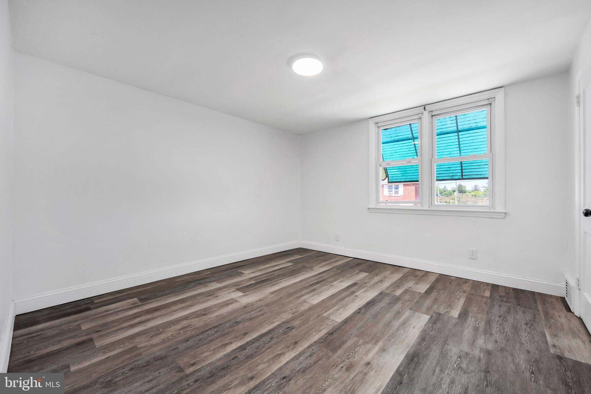 312 Golf Road Darby, PA 19023 - Photo 23 of 27 a view of an empty room with wooden floor and a window