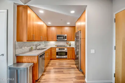 a large kitchen with stainless steel appliances granite countertop a stove and a refrigerator