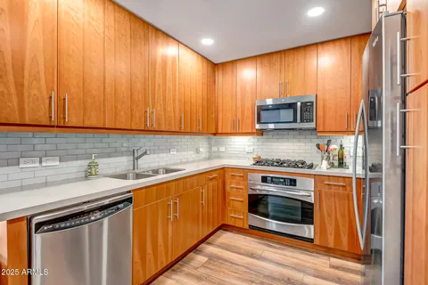 a kitchen with stainless steel appliances a stove a sink and a microwave