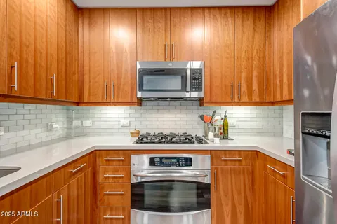 a kitchen with granite countertop cabinets stainless steel appliances and a counter space