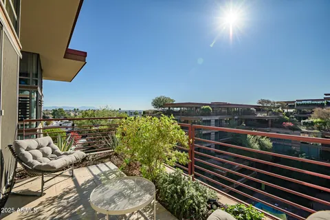a view of a balcony with two chairs and a potted plant