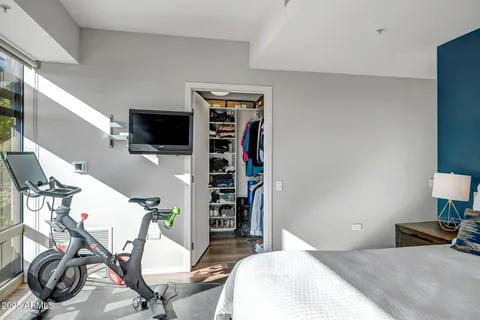 a bedroom with a bed a flat screen tv and dresser