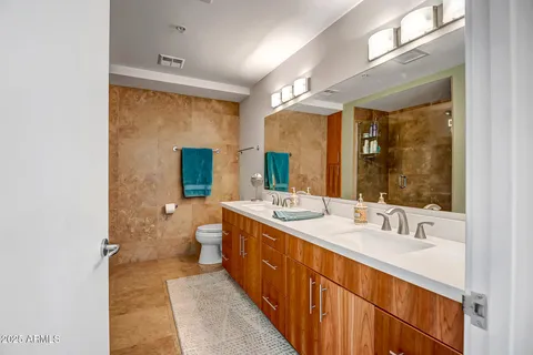 a bathroom with a double vanity sink toilet and mirror