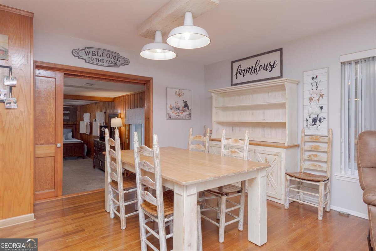 150 Moss Oaks Road Perry, GA 31069 - Photo 12 of 51 a dining room with wooden floor a chandelier a wooden table and chairs