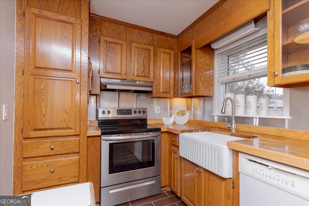 150 Moss Oaks Road Perry, GA 31069 - Photo 16 of 51 a kitchen with granite countertop stainless steel appliances and wooden cabinets
