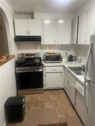 a kitchen with a stove and white cabinets