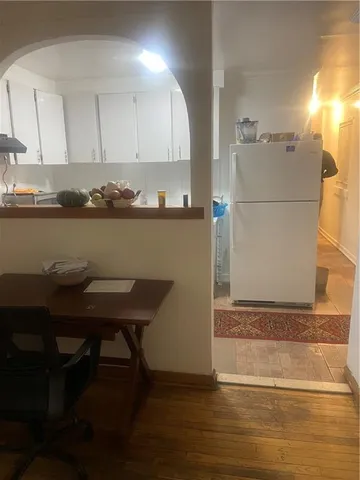 a room with a table chairs and a refrigerator